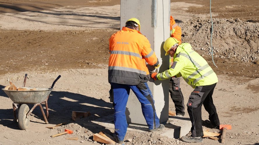 3 Bauarbeiter Helfen beim Platzieren des Pfeilers