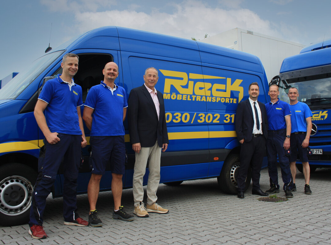 Eine Gruppe Männer vor einem Rieck Transporter.