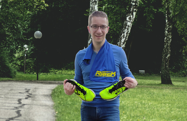 Marcel Uhr hält Sportschuhe in beiden Händen.