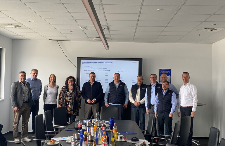 Eine Gruppe Menschen vor einem Bildschirm.