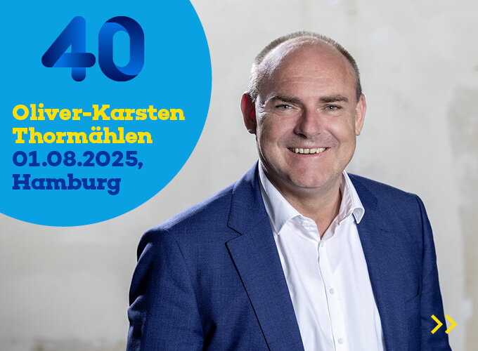 Porträt eines lächelnden Mannes in blauem Anzug vor hellem Hintergrund, daneben Text mit Namen, Datum und Ort.