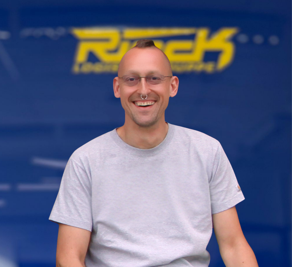 Mann mit Brille und grauem T-Shirt vor blauem Hintergrund mit gelbem Schriftzug.